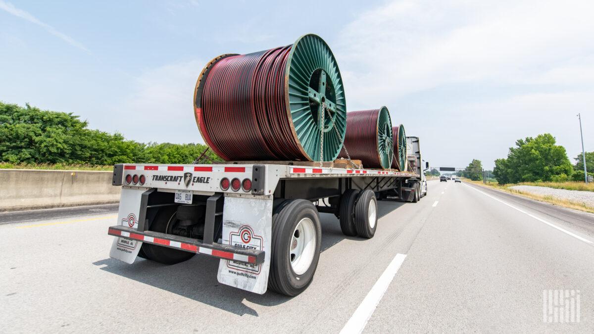 a loaded flatbed trailer on a highway 1200x675 1
