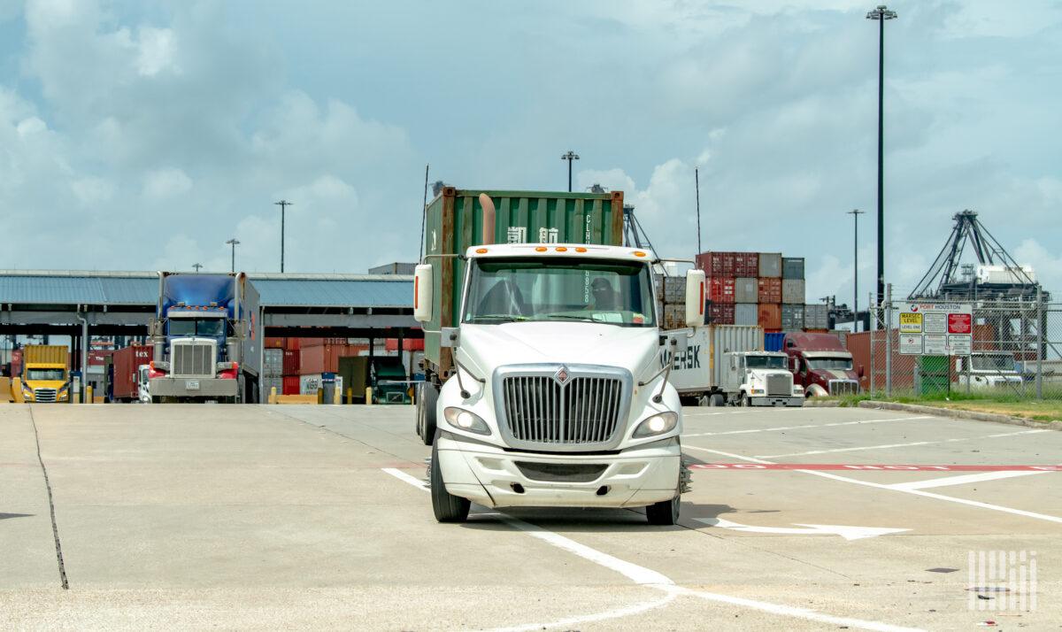 trucks leaving a port with containers 1200x714 1