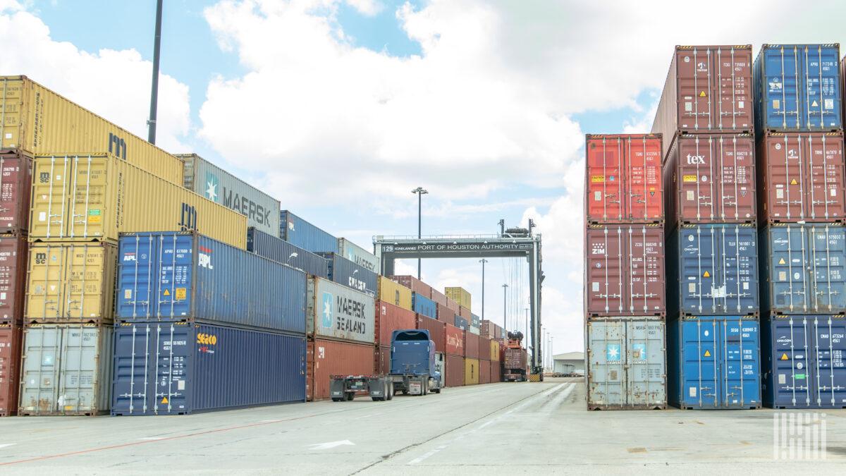 stacked ocean containers at a port 1200x675 1