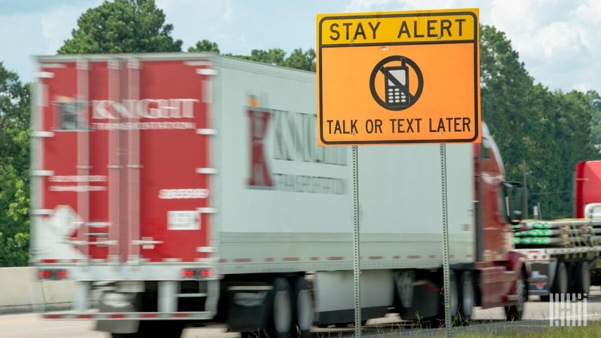 A Knight Transportation trailer on a highway with a no texting sign in the forefront 1200x675 1